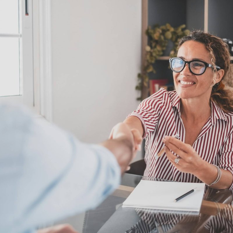 Smiling caucasian female hr manager handshake hire male candidate at job interview