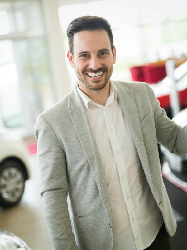 Car salesman calculating a price at the dealership office