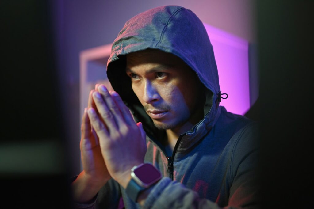 Male hacker in hoodie using computer for attack security to data digital internet network system.