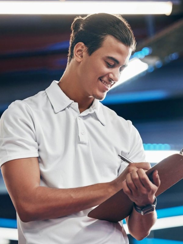 Personal trainer, coach and man writing on clipboard for gym membership, sign up and information fo