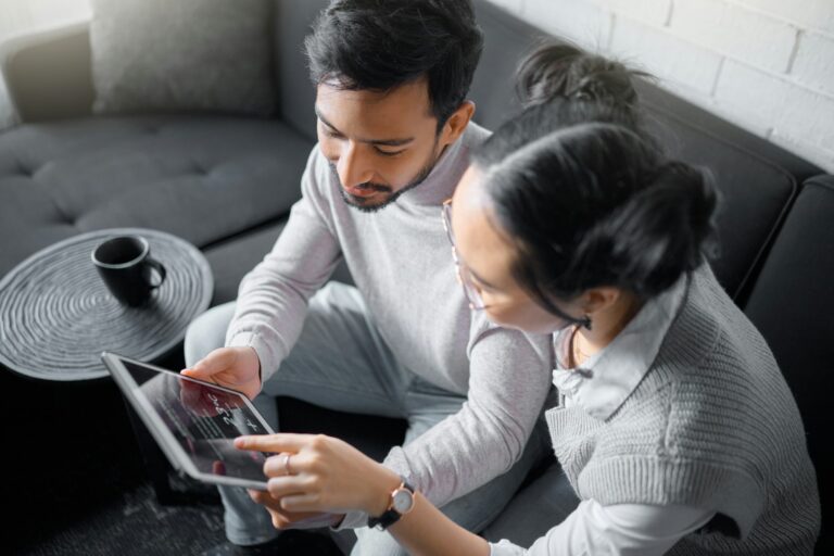 Tablet, sofa and couple with smart home technology for thermostat heating, apartment security netwo