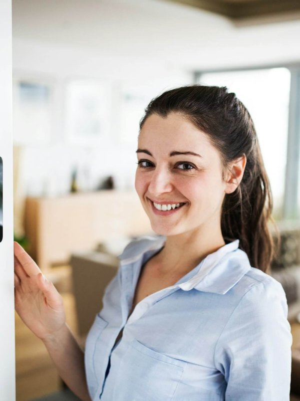 A woman looking at tablet with smart home screen.