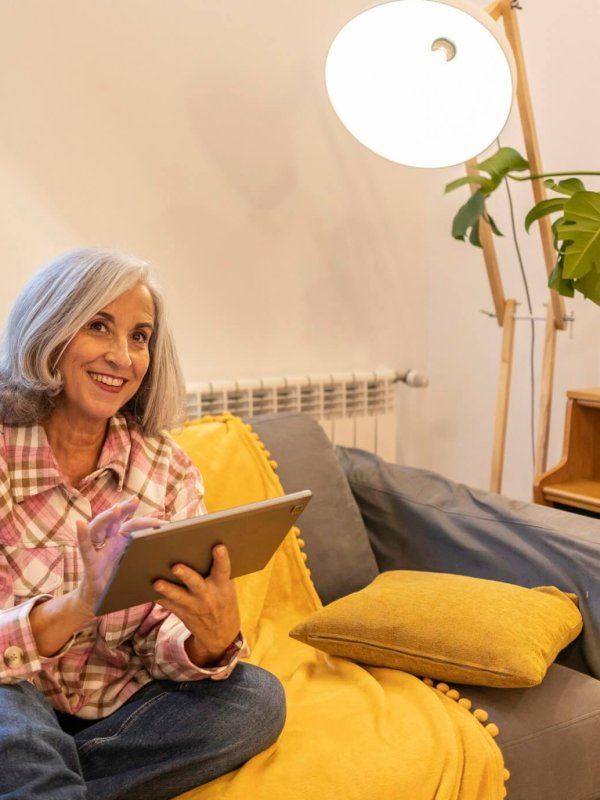 gray haired mature woman, smart home home control on tablet - use smart home app