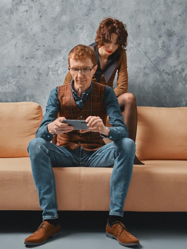 Middle aged man adjusts control of smart home on smartphone