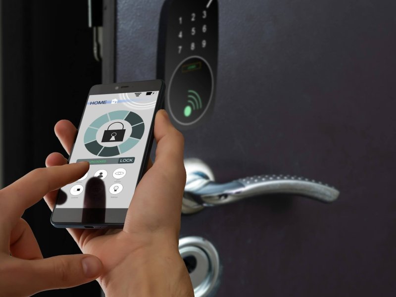 smart house, home automation, device with app icons. Man uses his smartphone with smarthome security