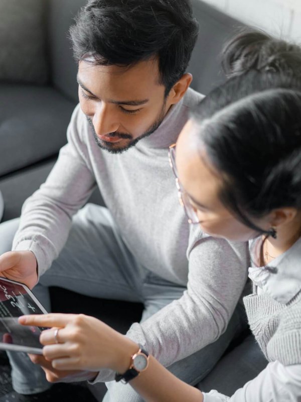 Tablet, sofa and couple with smart home technology for thermostat heating, apartment security netwo