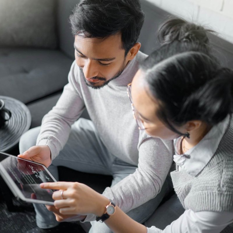 Tablet, sofa and couple with smart home technology for thermostat heating, apartment security netwo